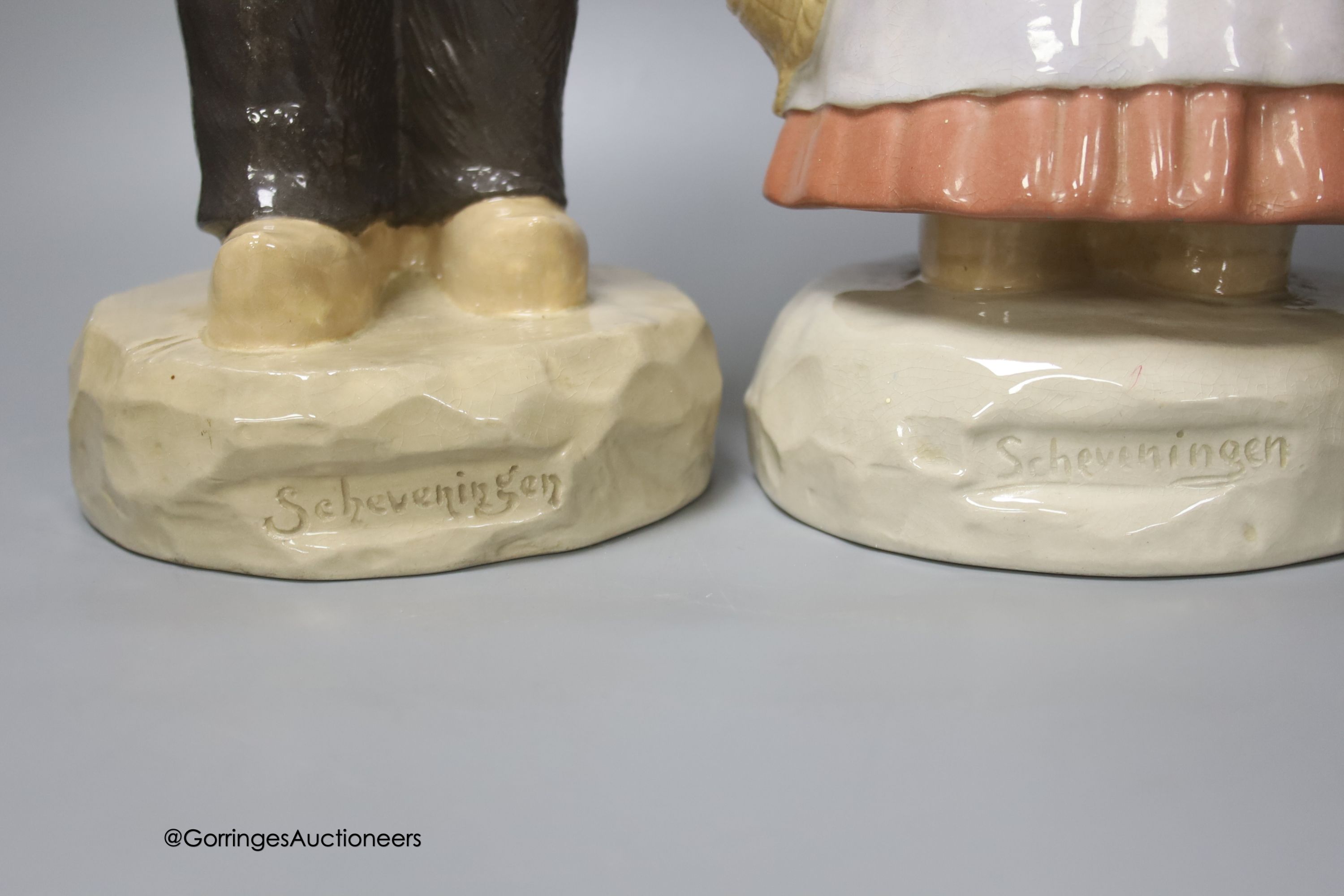 A pair of large Gouda pottery figures of a fisherman and fisherwoman, inscribed 'Scheveningen', 41cm